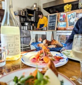 A picture of a typical french lunch on a table with a bottle of wine as you may find on one of our french food tours