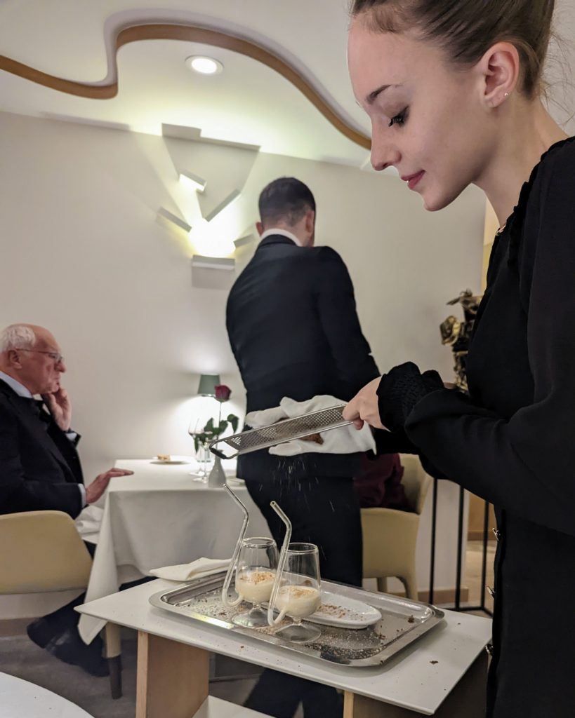 a photo of a waitress serving table side in a gastronomic restaurant on one of our food tours in Paris