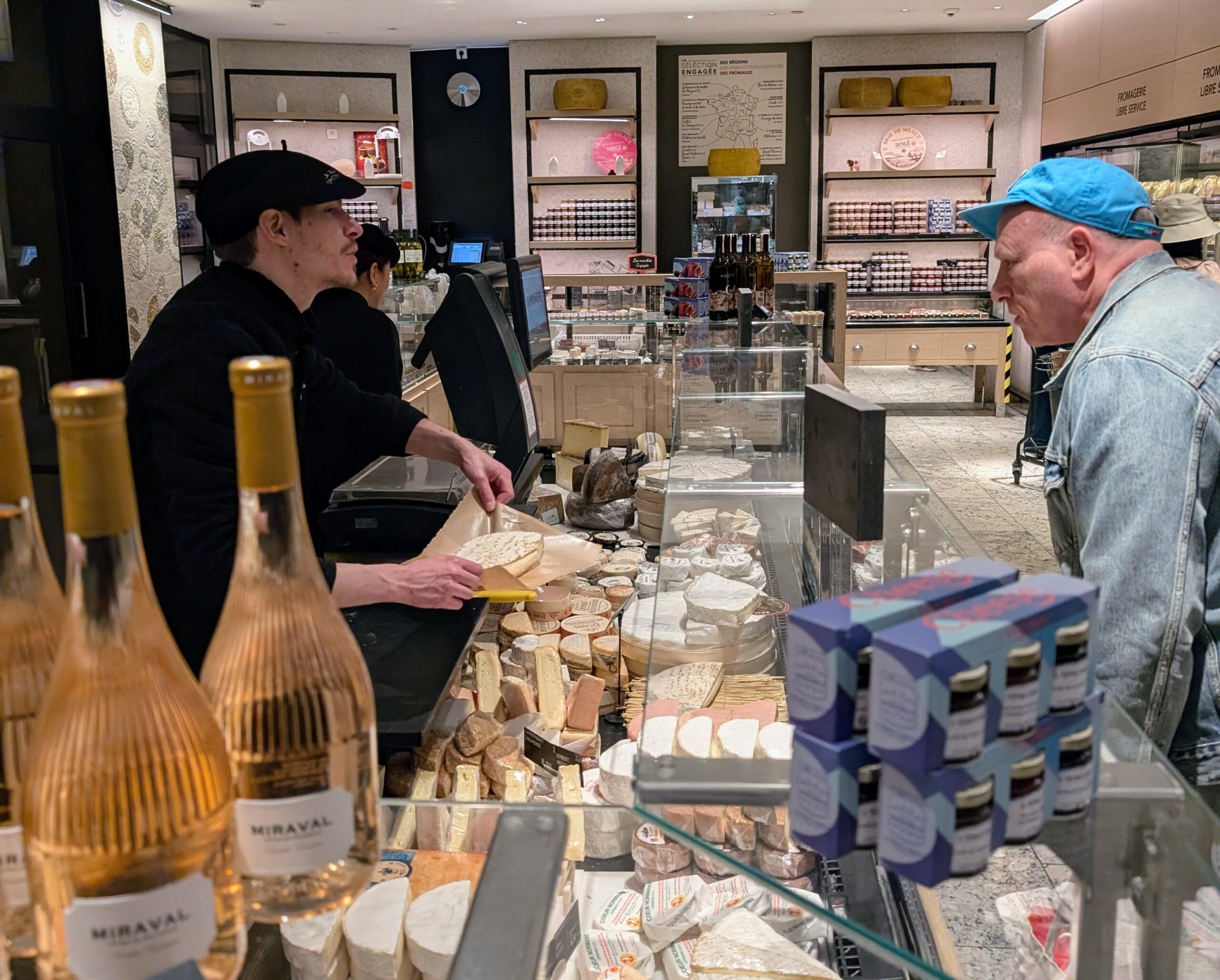 Customer Buying Cheese a picture of a tourist being served cheese at le bon marche in Paris on a foodie shopping trip