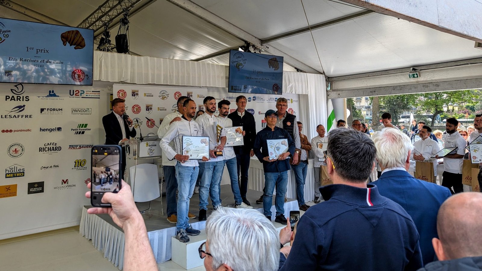 Paris Bread Festical - Best Croissant Winners Winners of the Best Croissant in Paris 2025 competition on stage at the Paris Bread Festival, receiving certificates and trophies beneath sponsor banners