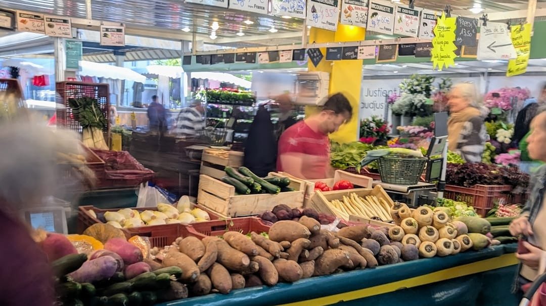 Fresh produce at a local food market in Boulogne-Billancourt with vegetables, shoppers and market stalls