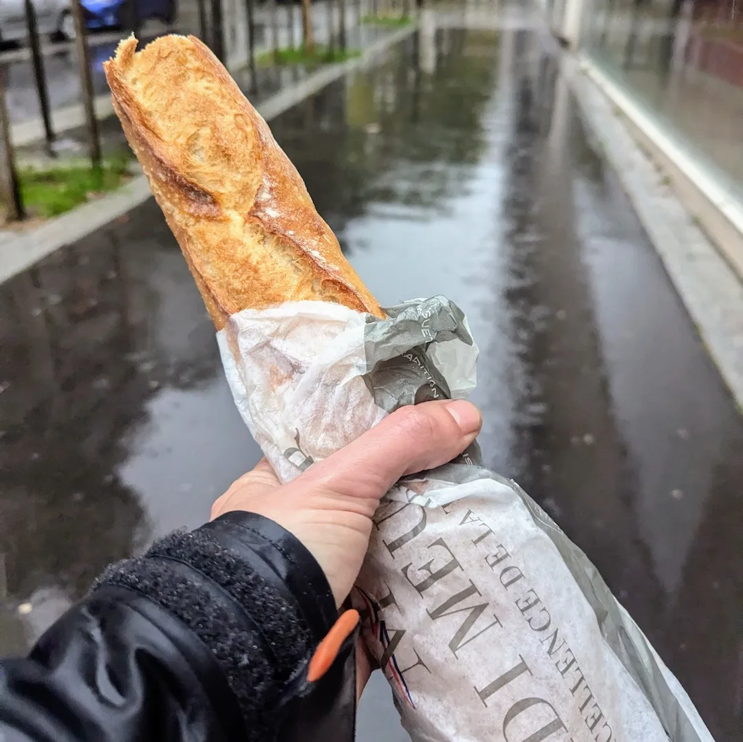 French Baguette in Boulogne-Billancourt Fresh French baguette from a bakery in Boulogne-Billancourt held on a rainy Paris street