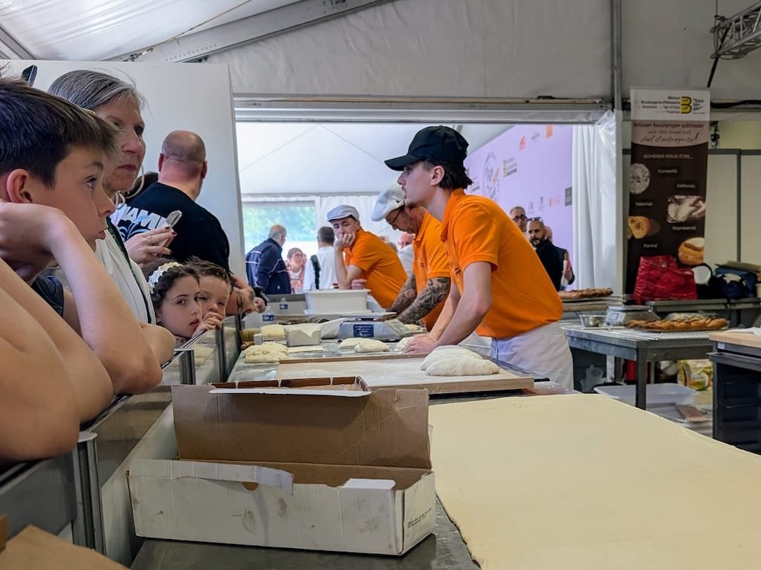 Visitors watching bakers prepare dough during a live demonstration at the Paris Bread Festival