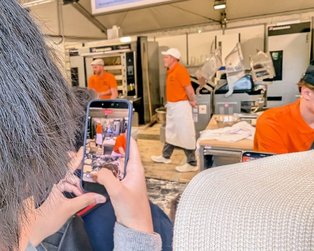 Visitors filming artisan bakers during the Paris Bread Festival at Notre-Dame